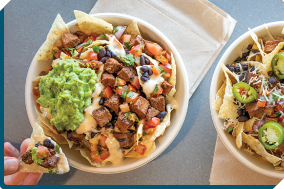 Freshly prepared QDOBA burrito bowl with rice, beans, salsa, and guacamole.