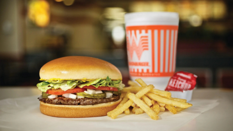 Delicious Whataburger burger with fries, drink, and fancy ketchup on a tray