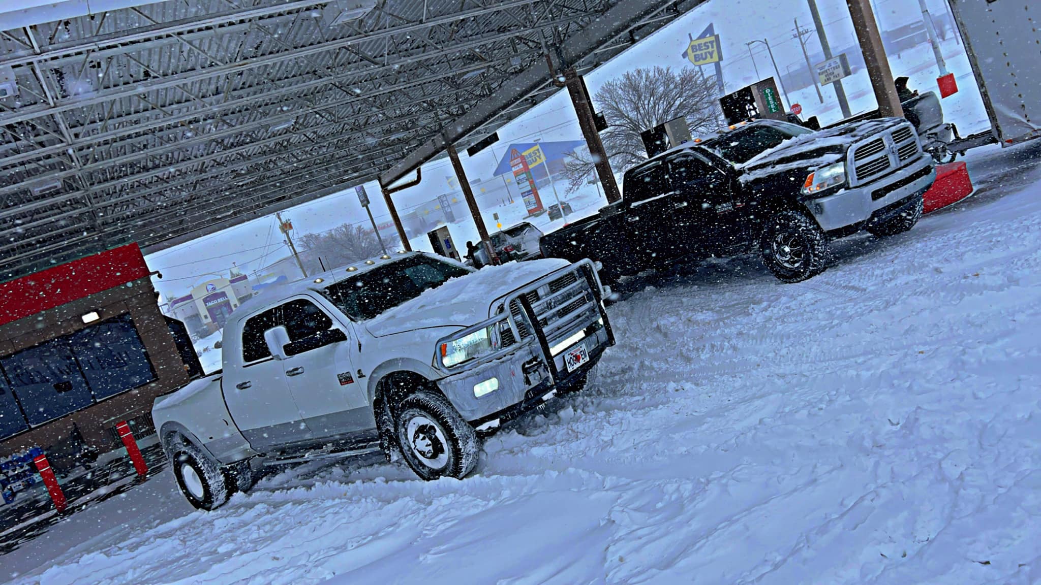 Eddies truck parked under a gas station canopy in Topeka during a heavy snowstorm, prepared for rescue missions in icy conditions.