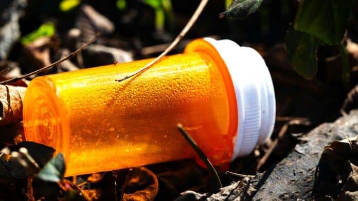 Empty, Orange Cup Lying Down on Ground by Chris F.