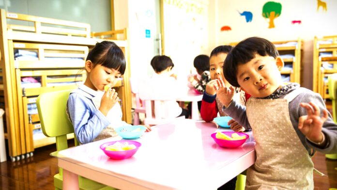 Three Toddler Eating on White Table by Naomi Shi